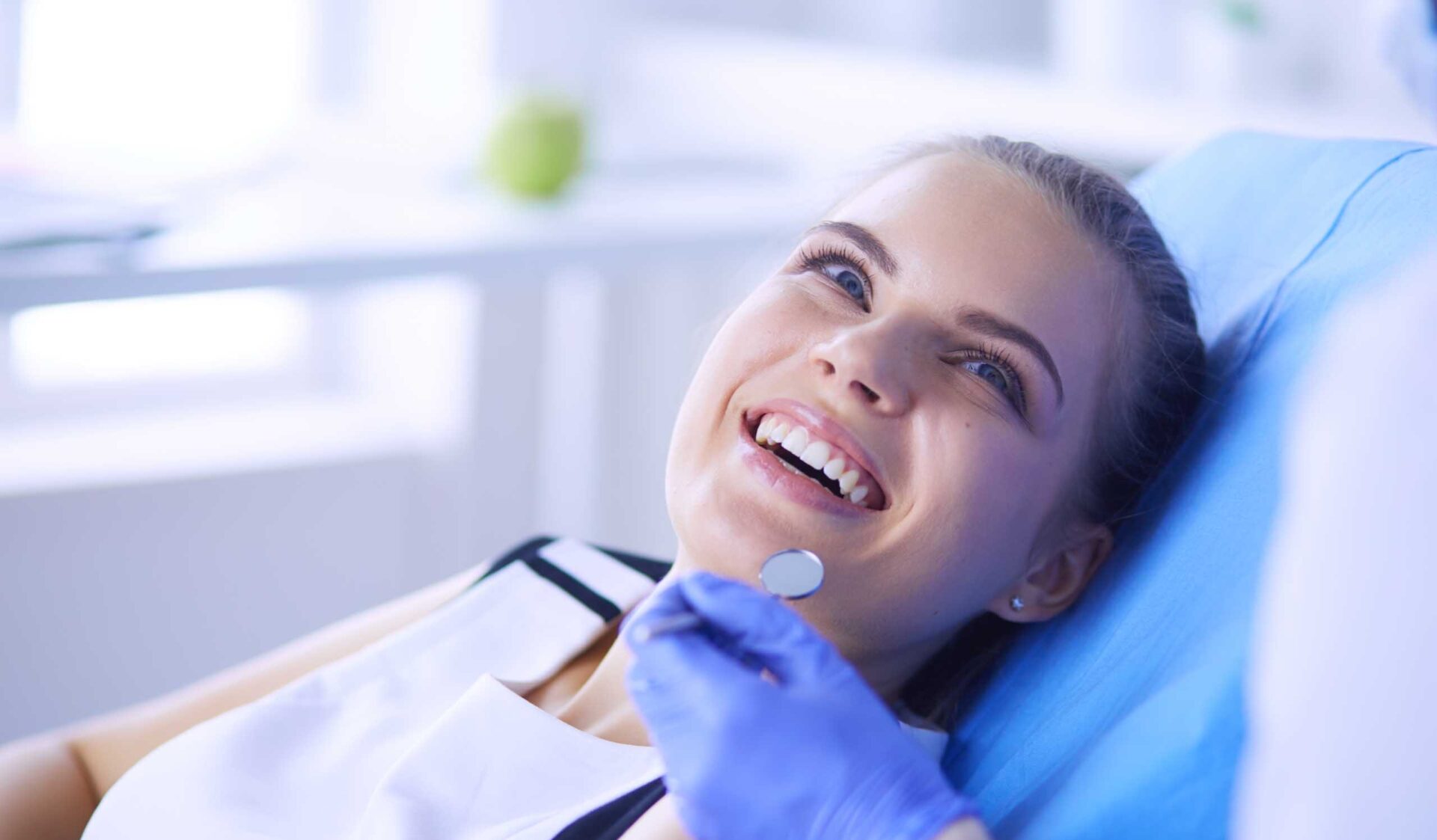 Young Female patient with pretty smile examining dental inspection at dentist office